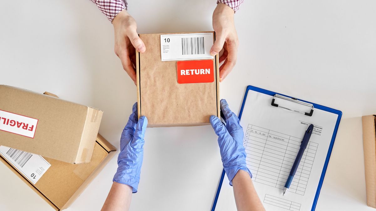 A pair of hands giving a return package to a gloved pair of hands to process