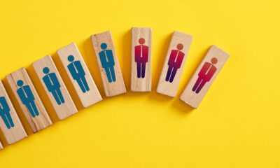 Wooden blocks that have worker graphics on them. Some are blue and and some are red to indicated laid off employees.