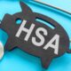 A black wooden pig that says HSA on it next to a stethoscope